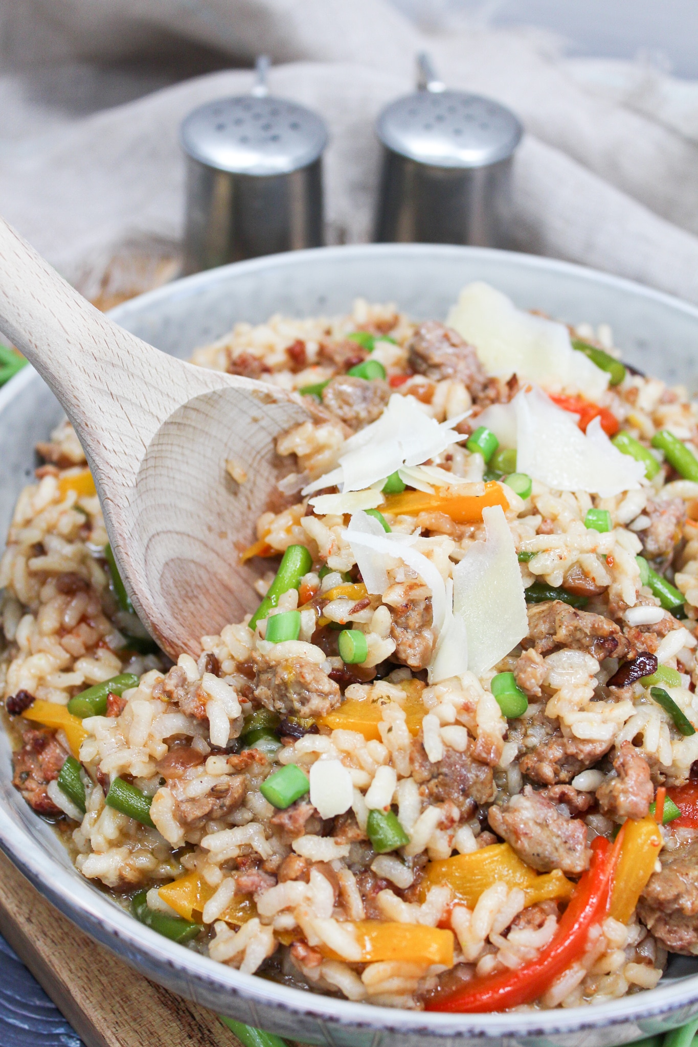 risotto served in a gray bowl with a wooden spoon