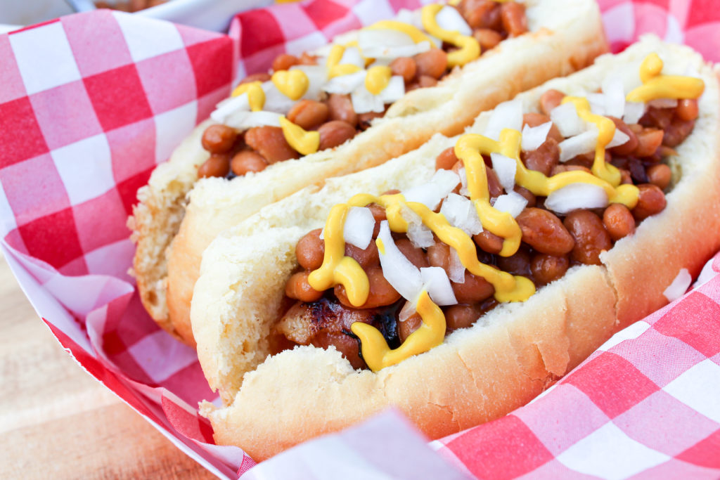 hot dog on the bun with beans and onion