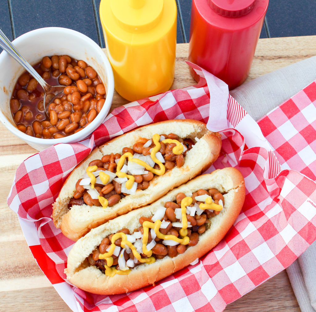 hot dog on the bun with beans and onion