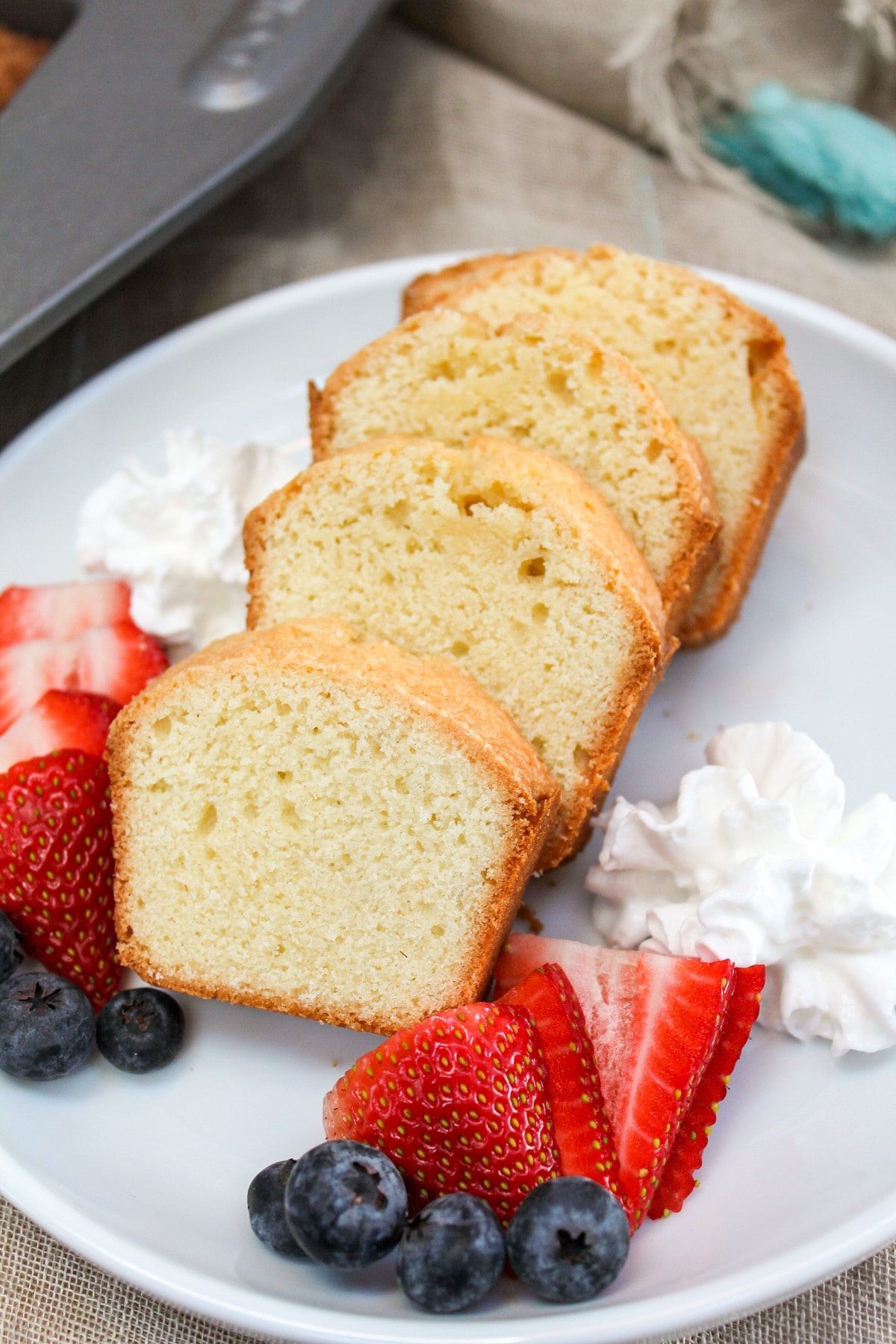 mini pound cake sliced with berries on a plate