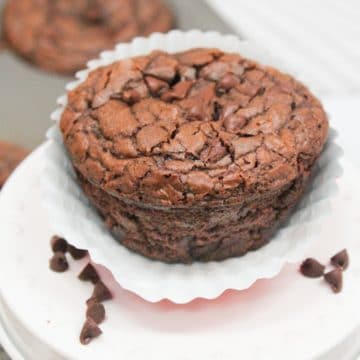 brownie muffin in a muffin wrapper with chocolate chips on the side