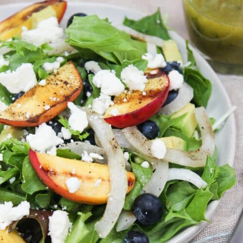 Lettuce topped with siced onions, grilled peaches, blueberries, and feta cheese.