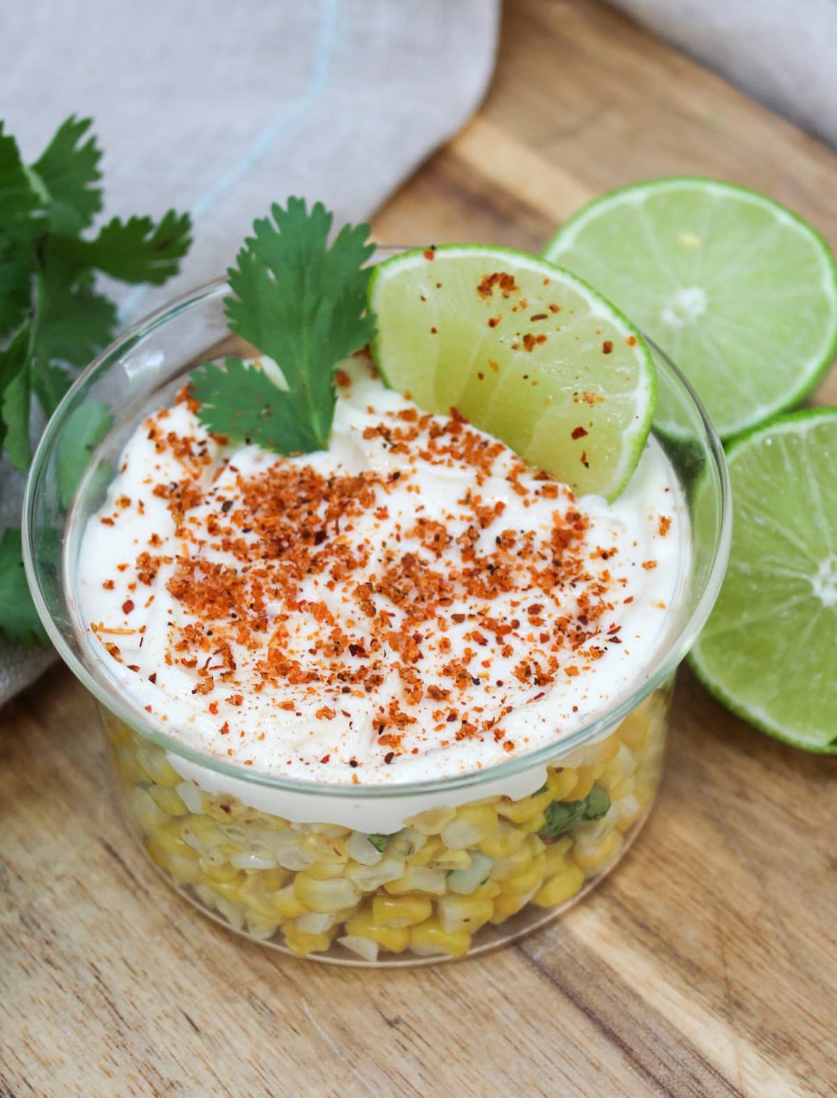 Mexican Street Corn Elote Bowl in a glass dish with lime and cilantro on top.