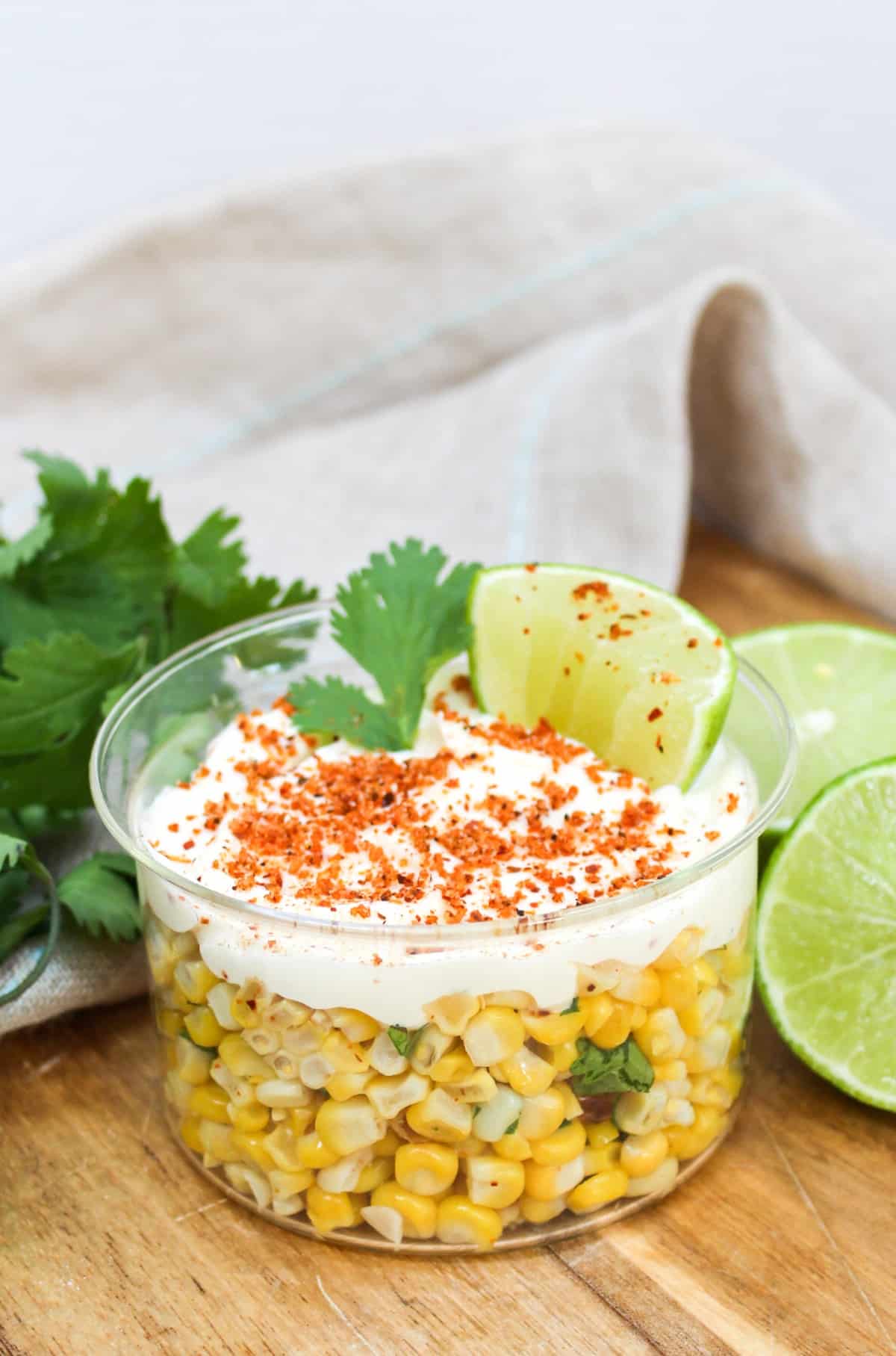 Mexican Street Corn Elote Bowl in a glass dish with lime and cilantro on top.