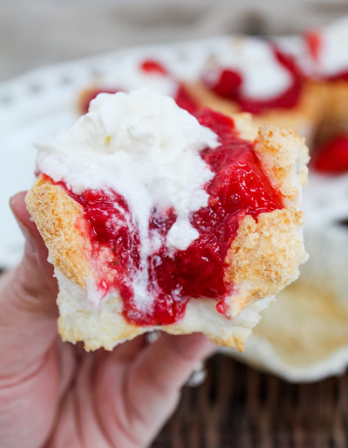 cupcake with a bite taken and held in hand.
